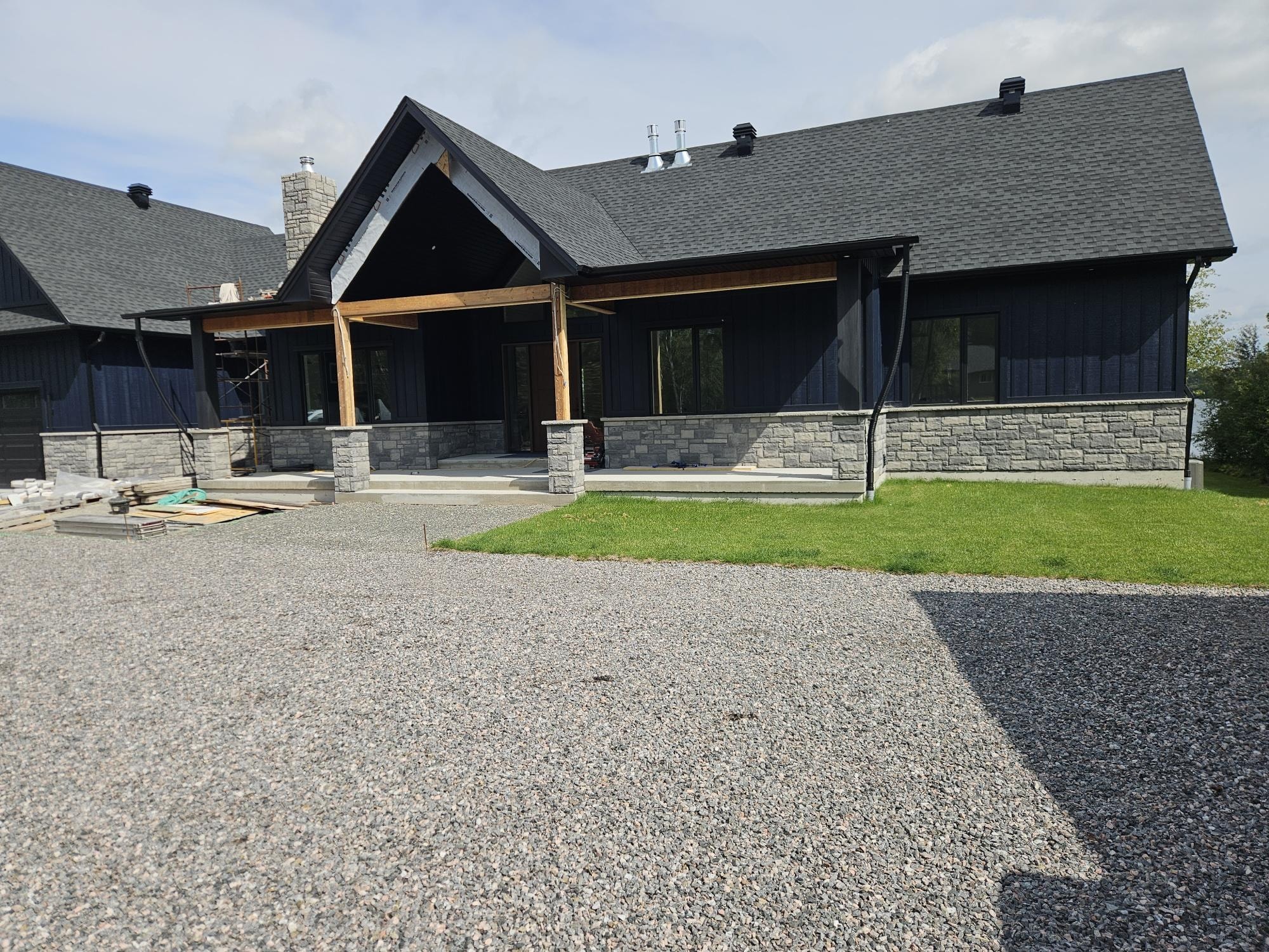 Dark home exterior with stone columns and veneer, A1 Creative Masonry