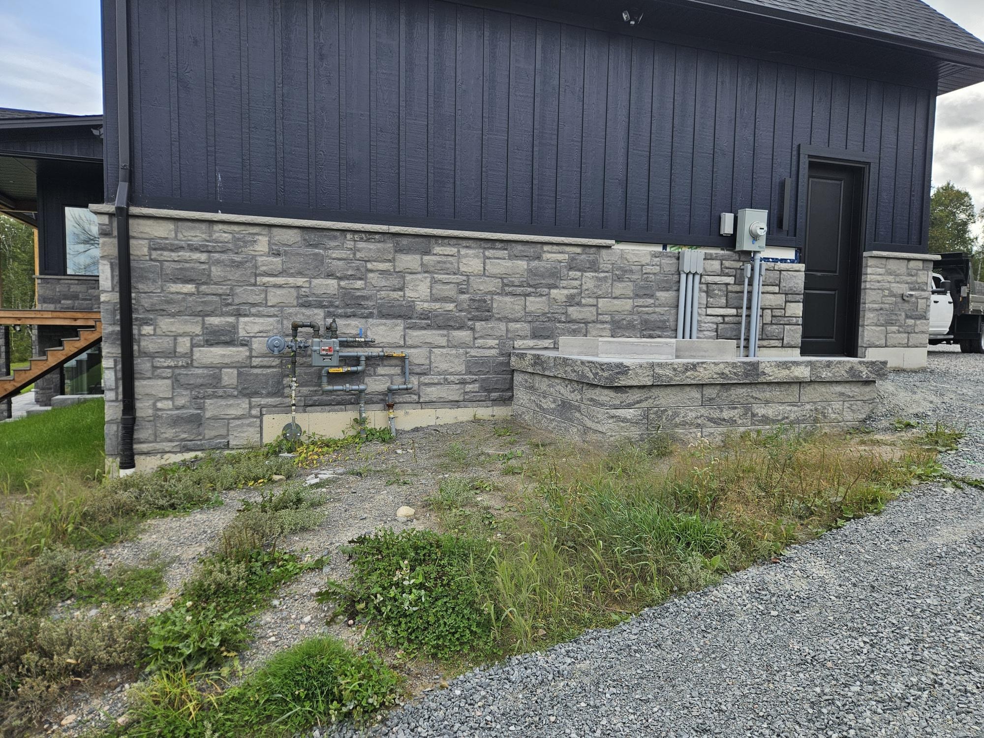Stone veneer foundation and entry steps on dark home, A1 Creative Masonry