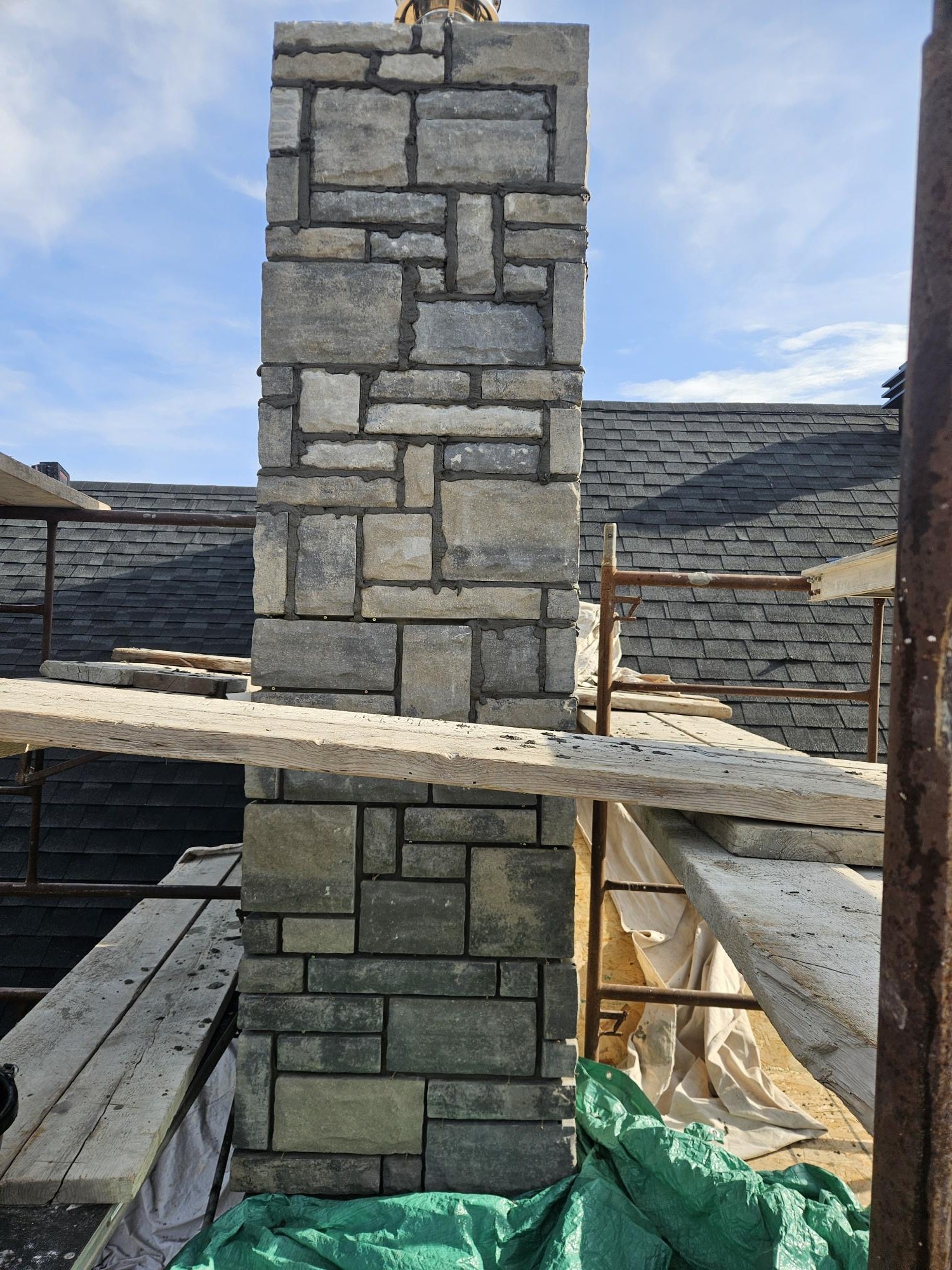 Stone chimney craftsmanship on scaffolding, A1 Creative Masonry